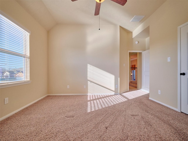 empty room featuring lofted ceiling, light colored carpet, and ceiling fan