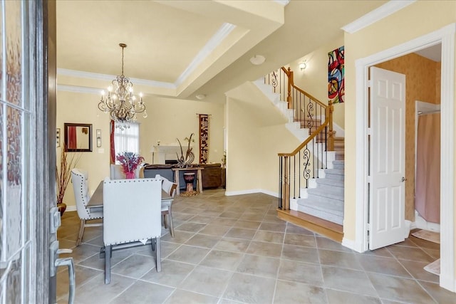 tiled dining space featuring an inviting chandelier, ornamental molding, and a raised ceiling