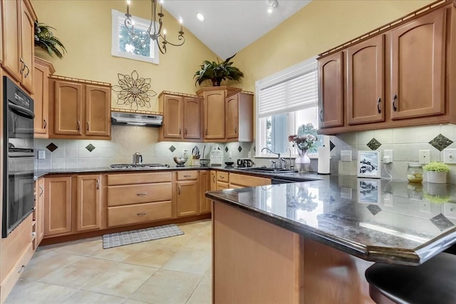 kitchen featuring light tile patterned flooring, sink, decorative light fixtures, black double oven, and stainless steel gas stovetop