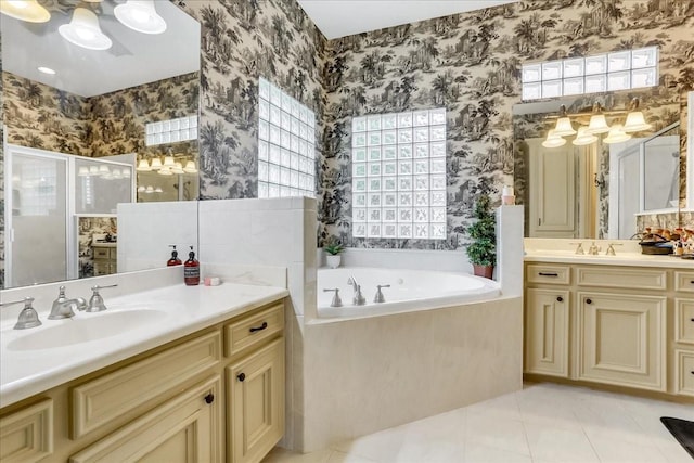 bathroom with tile patterned flooring, vanity, and separate shower and tub