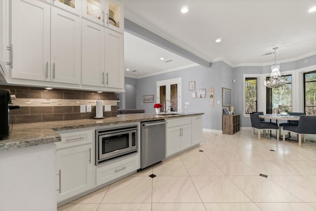 kitchen with stainless steel appliances, sink, hanging light fixtures, and white cabinets