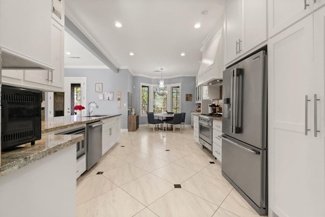 kitchen featuring premium appliances, ornamental molding, light stone countertops, white cabinets, and light tile patterned flooring