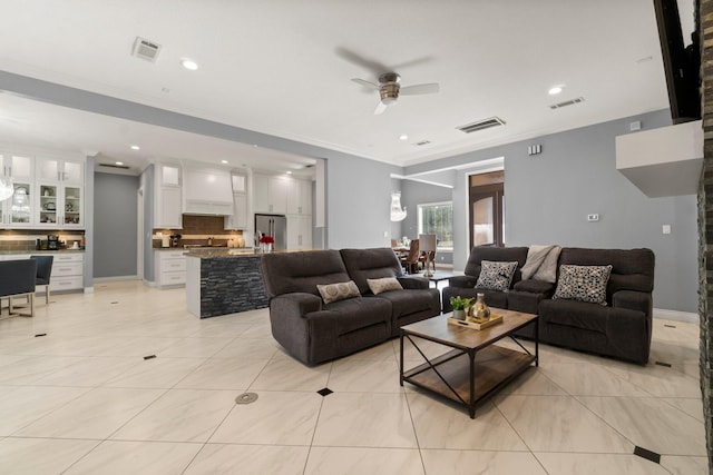 living room featuring light tile patterned floors, crown molding, and ceiling fan