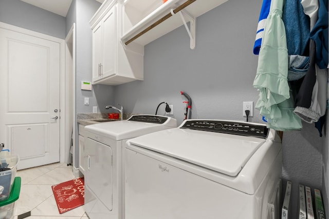 clothes washing area featuring cabinets, independent washer and dryer, light tile patterned flooring, and sink