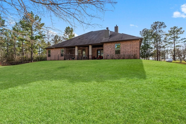 rear view of property with a lawn