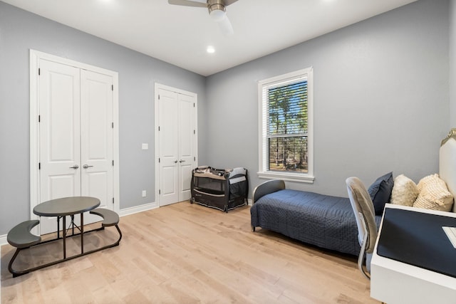 interior space featuring ceiling fan, light hardwood / wood-style flooring, and multiple closets