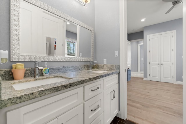 bathroom featuring wood-type flooring, vanity, and ceiling fan