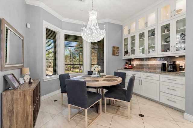 dining area with ornamental molding, light tile patterned floors, and a notable chandelier