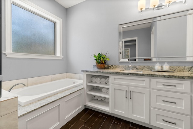 bathroom featuring vanity and a washtub