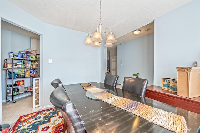 dining room featuring light tile patterned flooring, a chandelier, and a textured ceiling