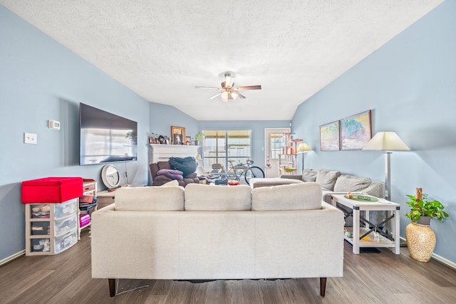 living room featuring hardwood / wood-style flooring, ceiling fan, vaulted ceiling, and a textured ceiling