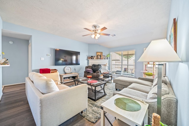 living room featuring a textured ceiling, dark hardwood / wood-style floors, and ceiling fan