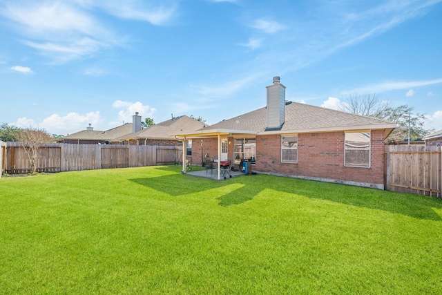 rear view of house featuring a yard and a patio