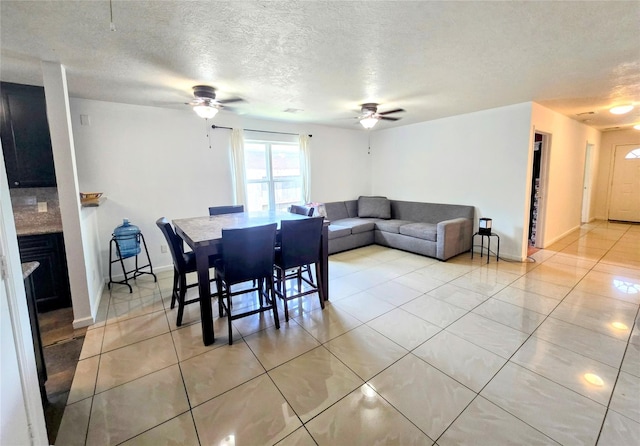 tiled dining area featuring a textured ceiling and ceiling fan