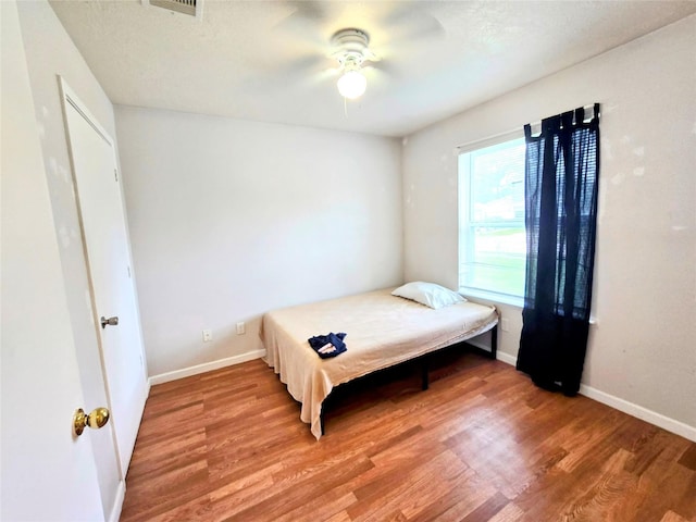 bedroom with wood-type flooring and ceiling fan