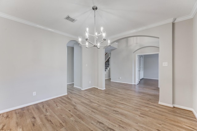 spare room with crown molding, a notable chandelier, and light wood-type flooring