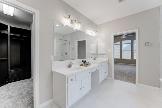 bathroom featuring vanity, ceiling fan, and walk in shower