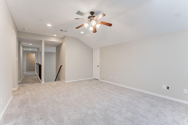 unfurnished room with vaulted ceiling, light colored carpet, and ceiling fan