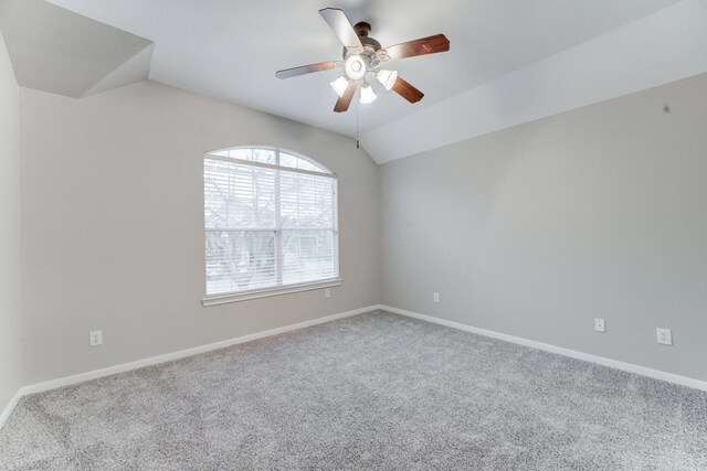 spare room with ceiling fan, lofted ceiling, and carpet