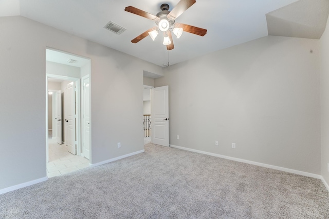 unfurnished bedroom with vaulted ceiling, connected bathroom, light carpet, and ceiling fan