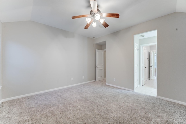 carpeted spare room featuring lofted ceiling and ceiling fan