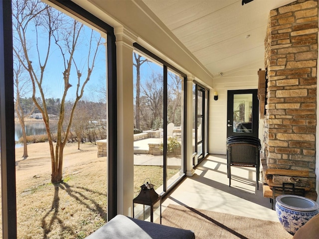 sunroom / solarium featuring a water view and lofted ceiling