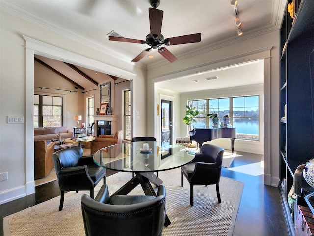 dining room with a water view, ceiling fan, crown molding, and vaulted ceiling