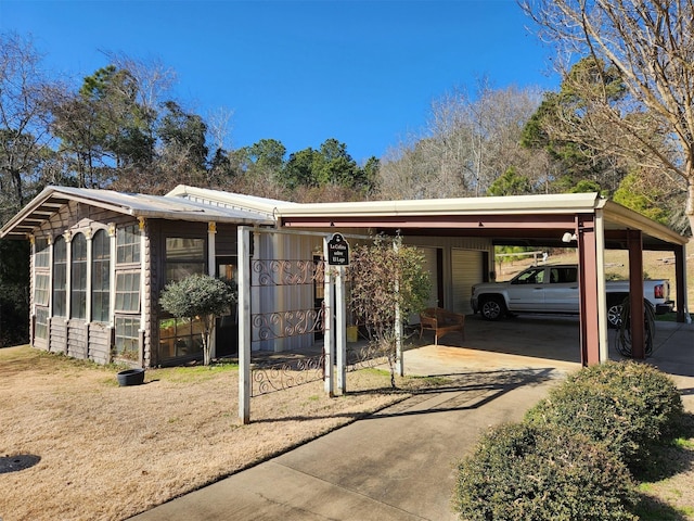 view of front of property with a carport and a sunroom