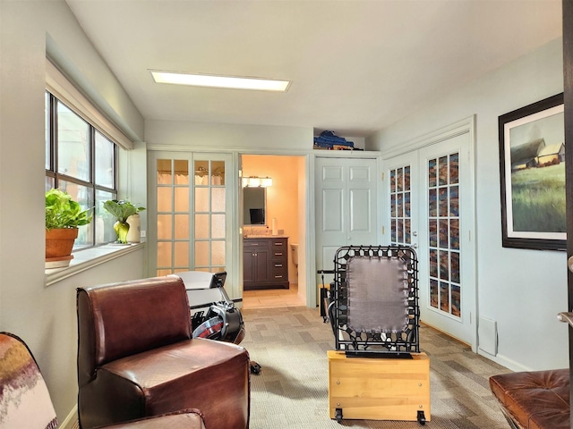 living area with french doors and light colored carpet