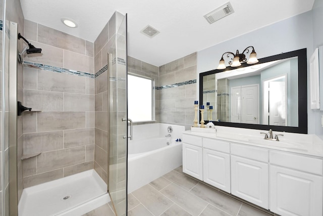 bathroom featuring tile patterned floors, vanity, independent shower and bath, and tile walls