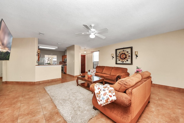 tiled living room with ceiling fan and a textured ceiling