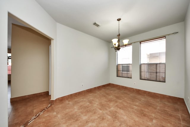 empty room featuring a chandelier