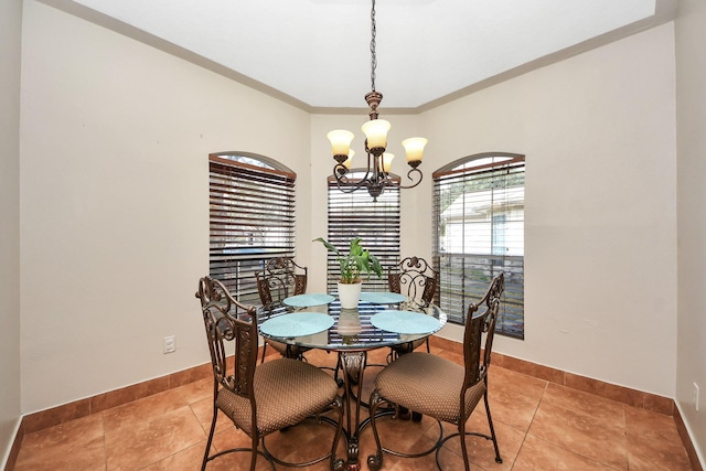 dining area with ornamental molding, a chandelier, and light tile patterned flooring