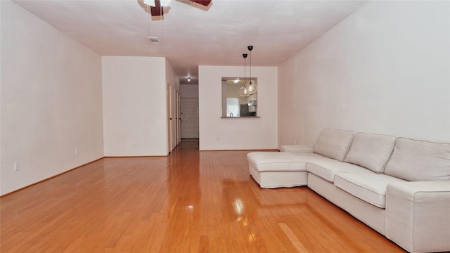 unfurnished living room featuring hardwood / wood-style flooring and ceiling fan