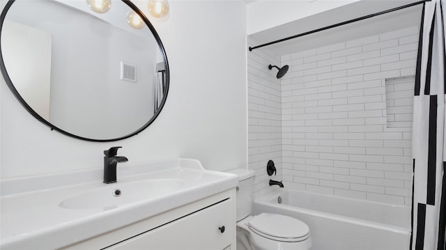 full bathroom featuring vanity, tiled shower / bath combo, and toilet