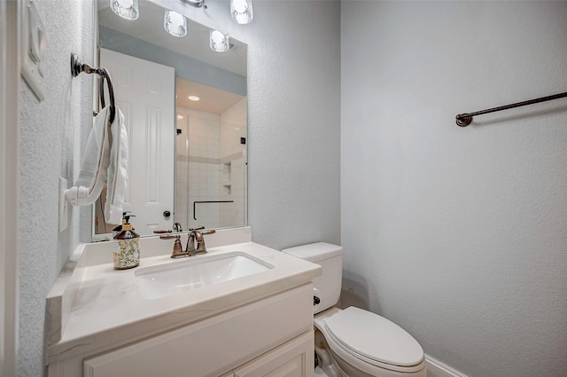 bathroom featuring toilet, vanity, and an enclosed shower