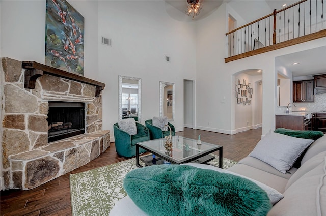 living room featuring dark hardwood / wood-style flooring and a stone fireplace