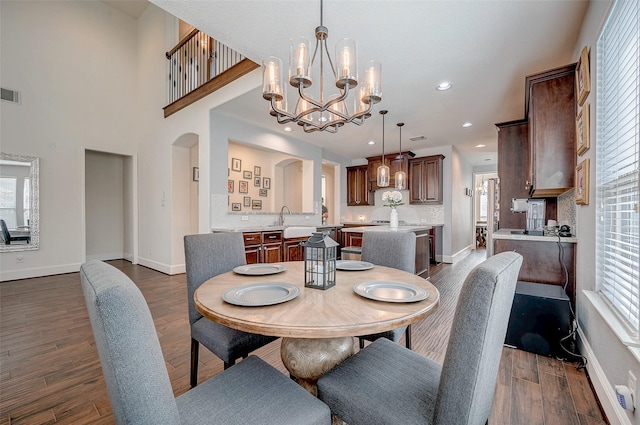 dining room featuring dark hardwood / wood-style flooring, sink, and a chandelier