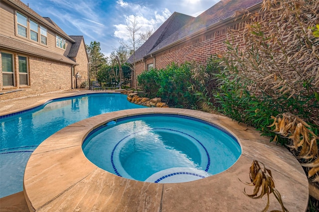 view of pool featuring an in ground hot tub