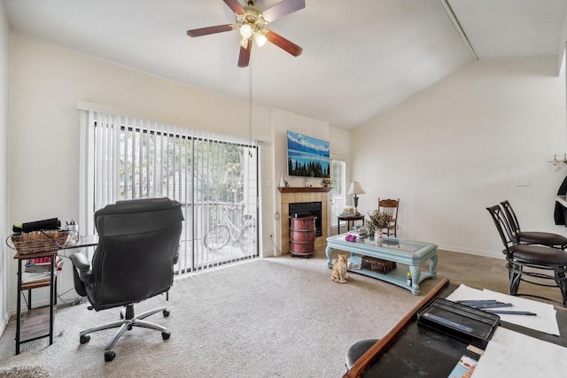 carpeted home office featuring vaulted ceiling, a tile fireplace, and ceiling fan