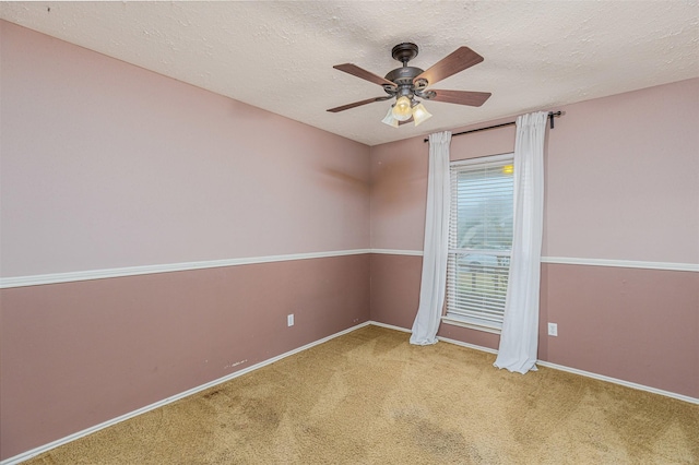 spare room with ceiling fan, carpet, and a textured ceiling