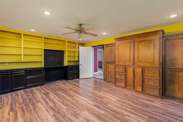 kitchen featuring ceiling fan, a textured ceiling, and light wood-type flooring