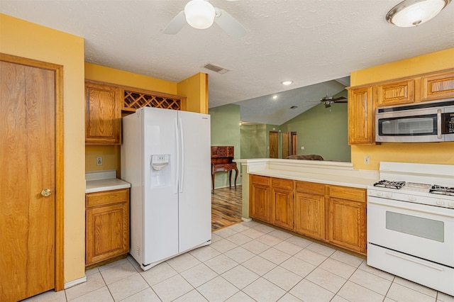 kitchen featuring light tile patterned floors, white appliances, a textured ceiling, and ceiling fan