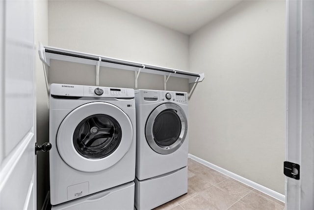 clothes washing area featuring washing machine and dryer and light tile patterned flooring