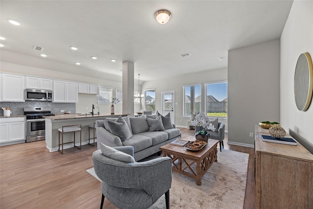 living room featuring a notable chandelier and light hardwood / wood-style flooring