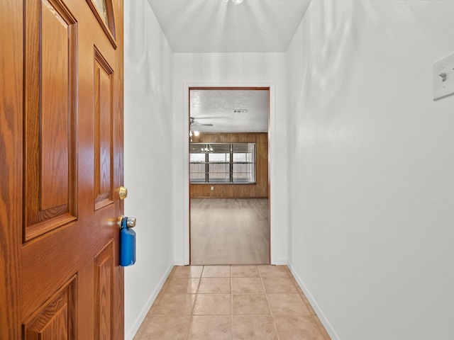 hallway with light tile patterned floors and a textured ceiling