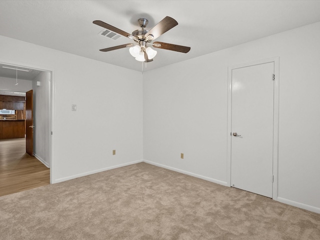 carpeted spare room with ceiling fan