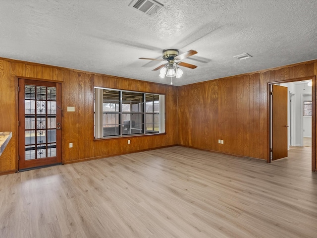 unfurnished room with ceiling fan, a wealth of natural light, and light hardwood / wood-style floors