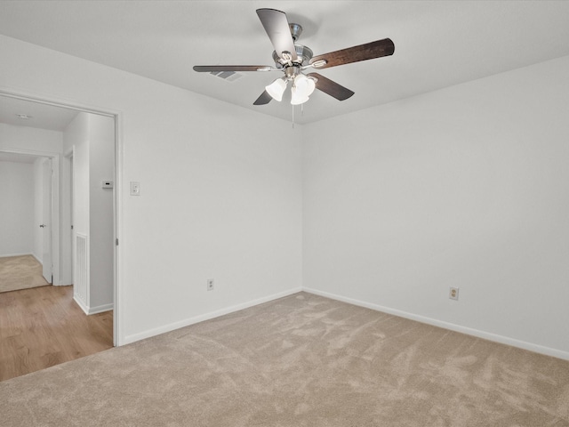 spare room featuring ceiling fan and light colored carpet