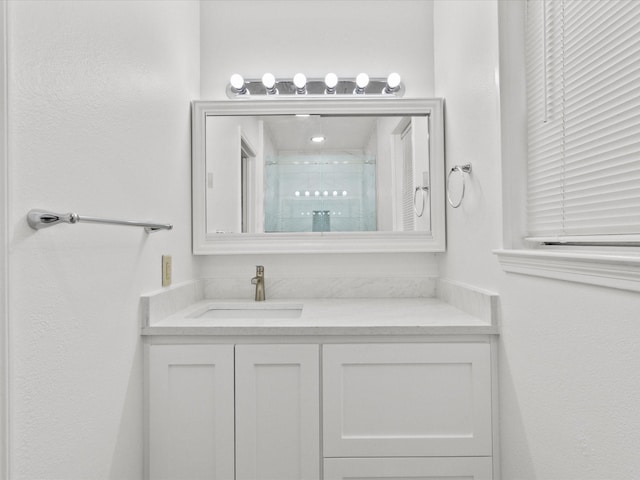 bathroom with vanity and a shower with door